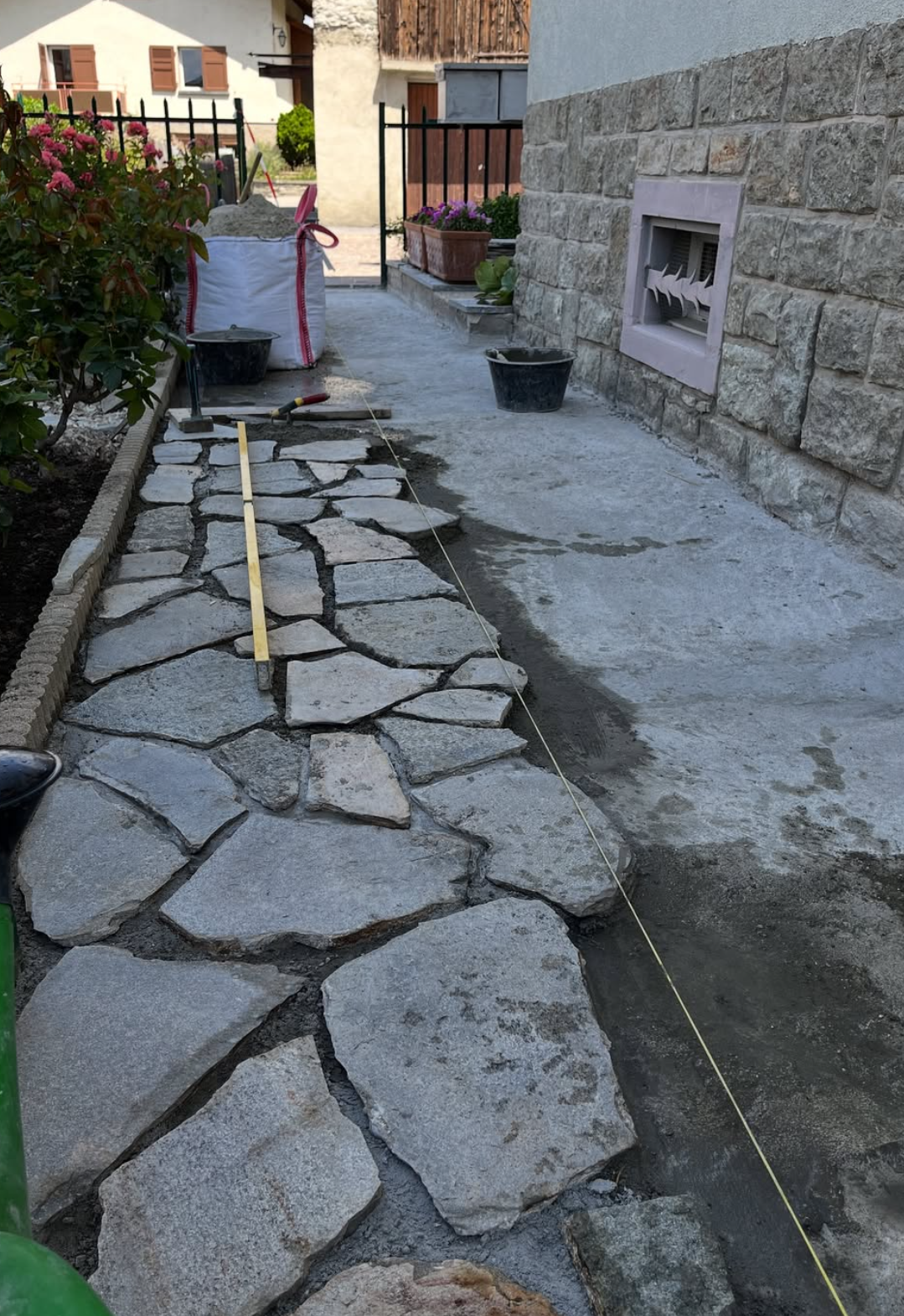 Pose des pierres polygonales en cours, alignées au cordeau