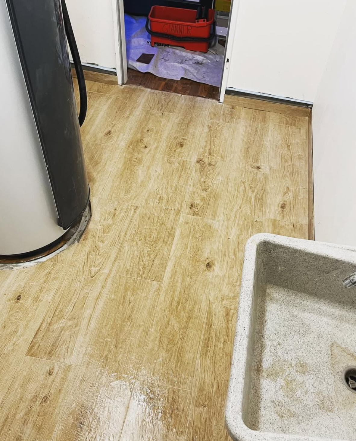 Carrelage imitation parquet posé autour des équipements du local technique
