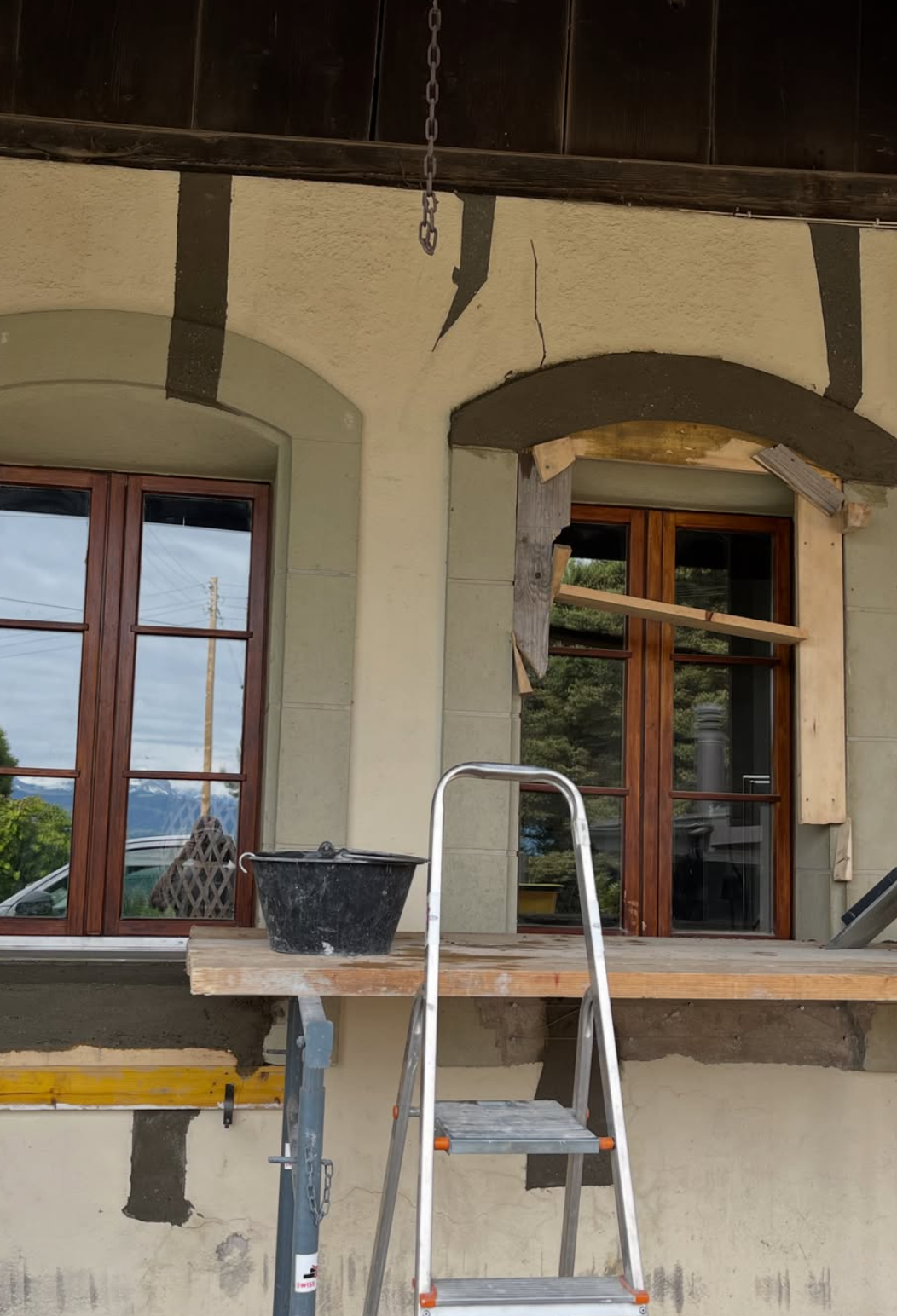 Façade fissurée et embrasure de fenêtre étayée pendant les travaux