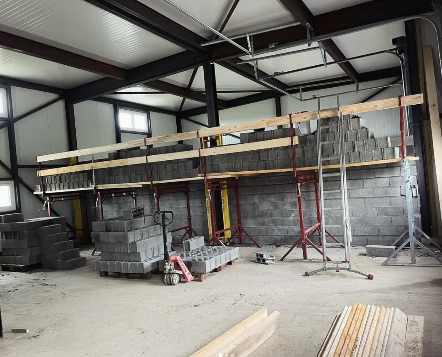 Élévation des murs en blocs avec échafaudage dans la halle