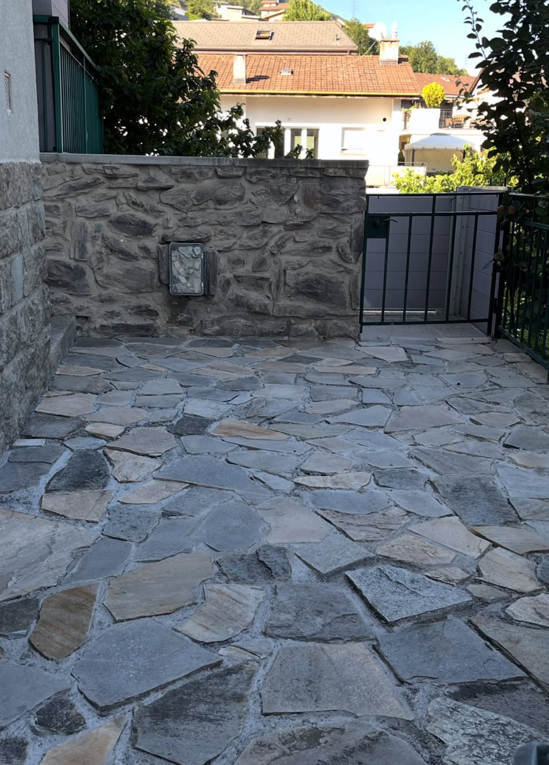 Terrasse en pierres naturelles polygonales devant un mur en pierre