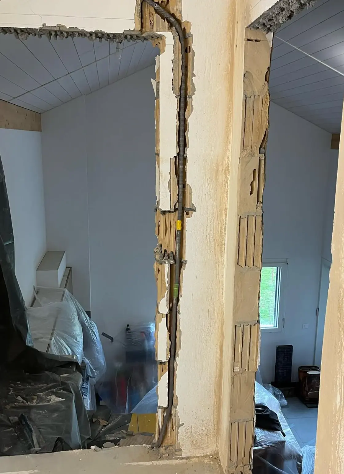 Percement en cours avec conduite électrique apparente dans l’embrasure